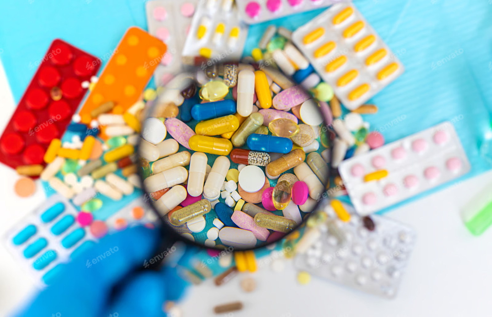 Assorted tablets and capsules under a magnifying glass